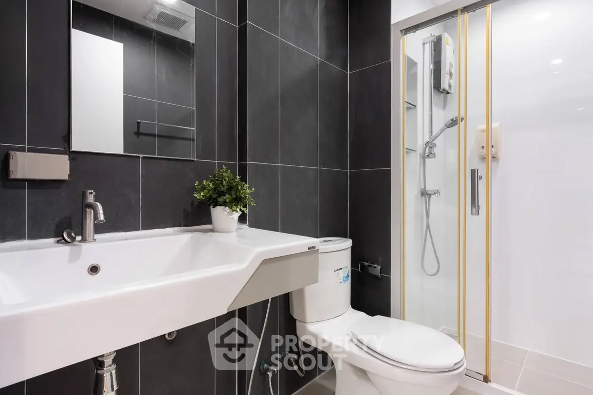Modern bathroom with sleek fixtures and elegant black tile design.