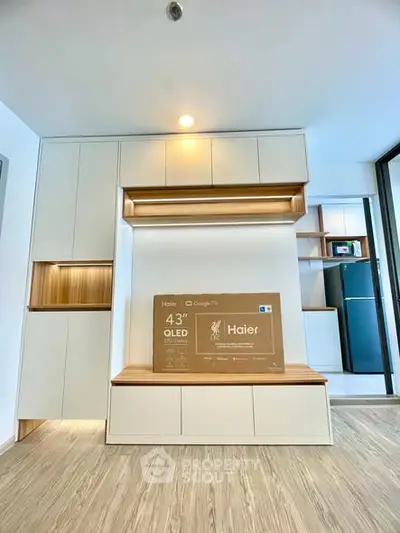 Modern living room with built-in storage and new Haier OLED TV, showcasing sleek design and functionality.