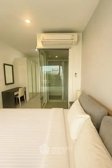 Modern bedroom with air conditioning and glass sliding door to balcony