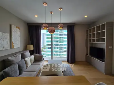 Modern living room with stylish decor and city view, featuring a cozy sofa and elegant lighting.