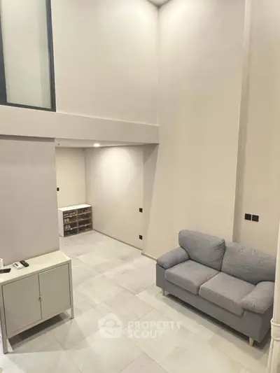 Modern minimalist living room with high ceiling and cozy gray sofa