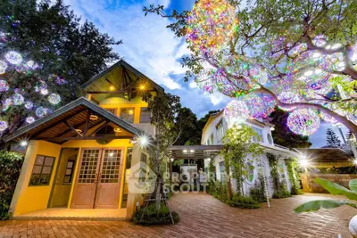 Charming two-story house with festive outdoor lighting and lush greenery