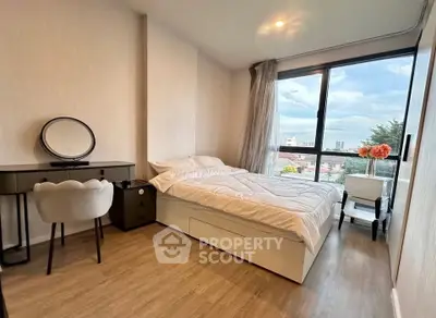 Modern bedroom with large window and stylish decor in a high-rise apartment.