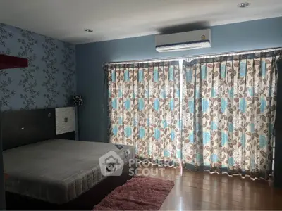 Spacious bedroom with stylish wallpaper and large windows for natural light.