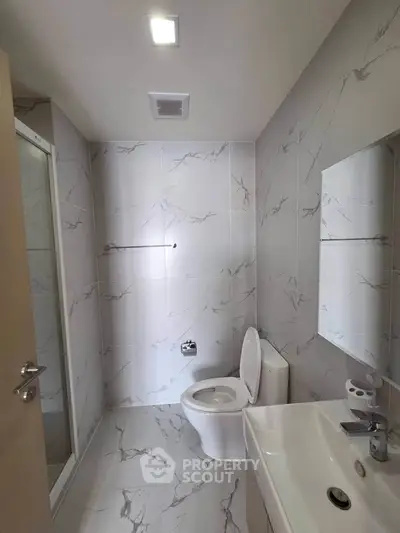 Modern bathroom with marble tiles and sleek fixtures in a contemporary apartment.