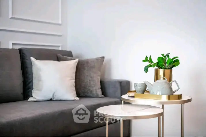Stylish living room with modern gray sofa and elegant side tables, perfect for cozy relaxation.