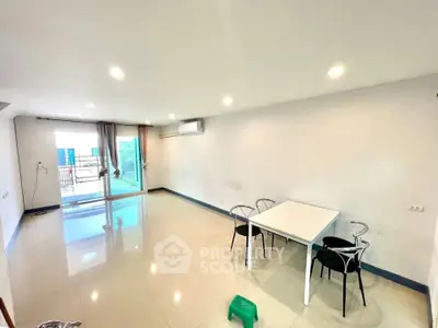 Spacious living room with modern decor and balcony access