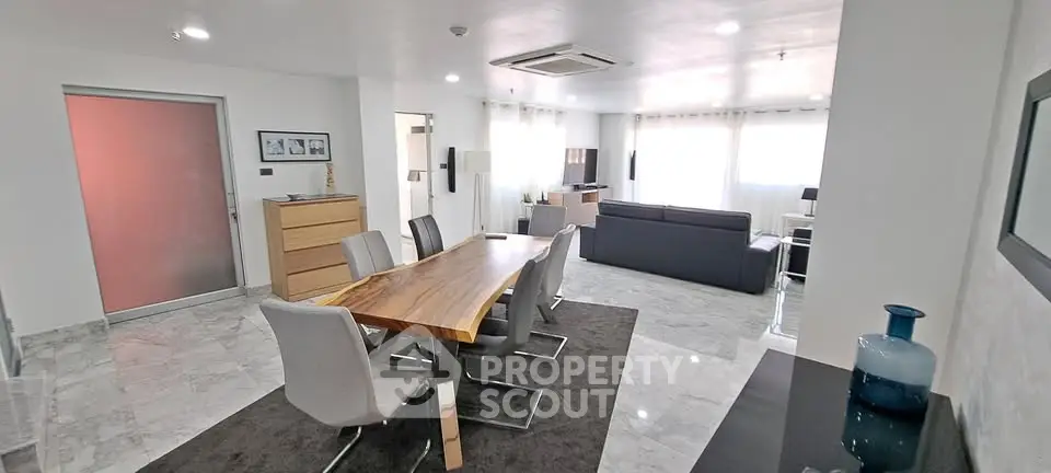 Spacious modern living and dining area with elegant furniture and natural light.