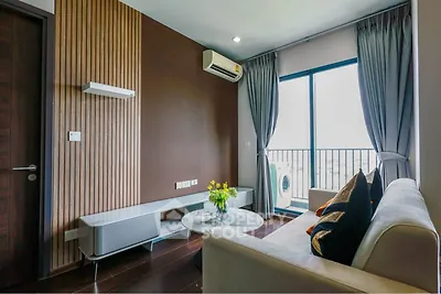 Modern living room with balcony view, featuring sleek furniture and stylish decor.