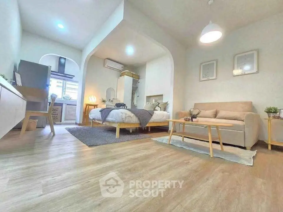 Spacious modern living room with cozy seating and stylish decor in open-plan apartment.