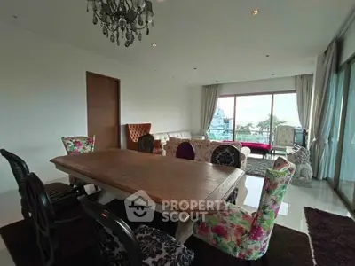 Spacious living room with elegant dining set and large windows offering a stunning view.