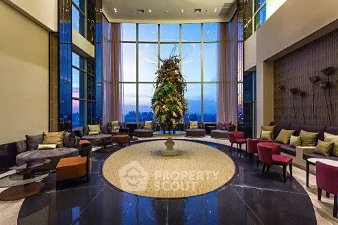 Luxurious high-rise building lobby with elegant seating and stunning city view.