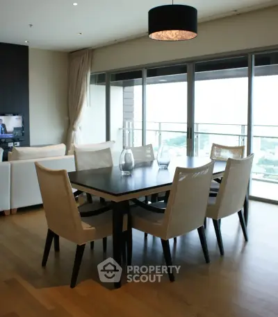 Spacious dining area with elegant furniture and large windows offering a stunning view.