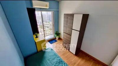 Cozy bedroom with city view, featuring modern wardrobe and air conditioning.