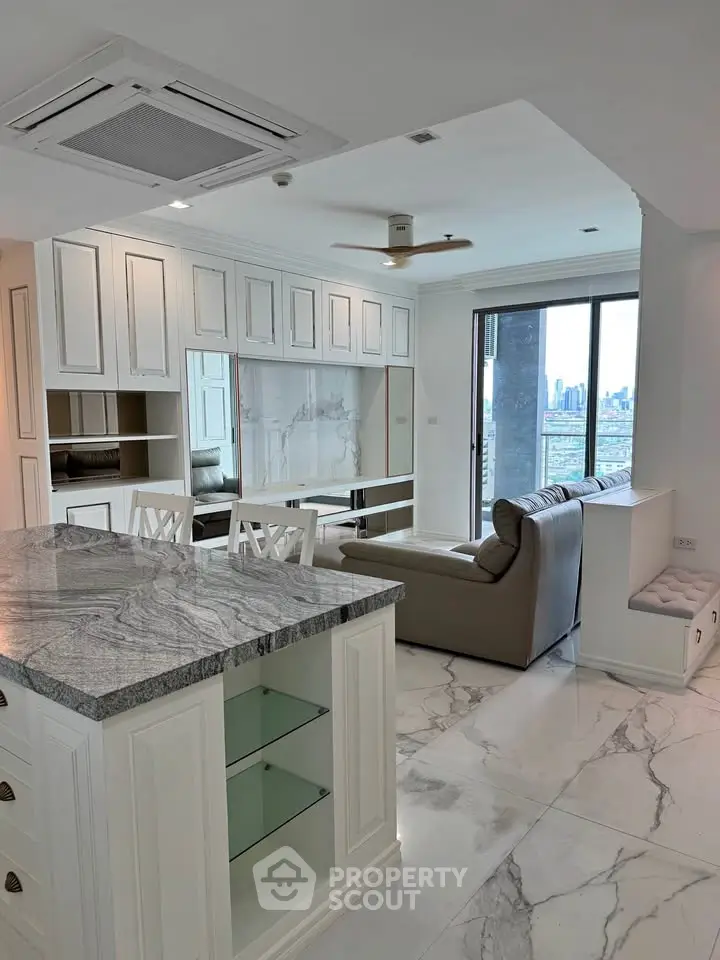 Luxurious open-plan living room with marble flooring and city view, featuring elegant kitchen island and modern furnishings.