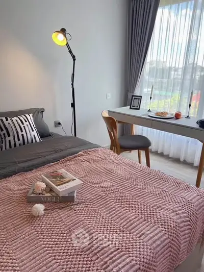 Cozy bedroom with stylish decor, featuring a comfortable bed, modern desk, and large window with natural light.