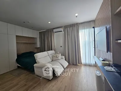 Modern living room with cozy seating and natural light, featuring sleek design and stylish decor.