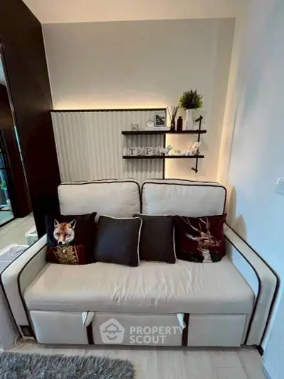 Cozy living room with stylish sofa and decorative pillows, perfect for relaxation.