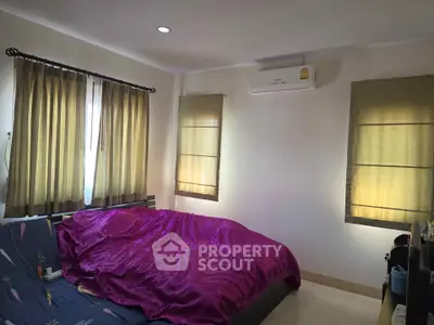 Cozy bedroom with vibrant bedding and natural light from multiple windows.
