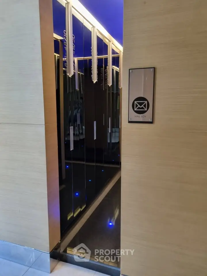 Modern building entrance with sleek mailbox design and ambient lighting.