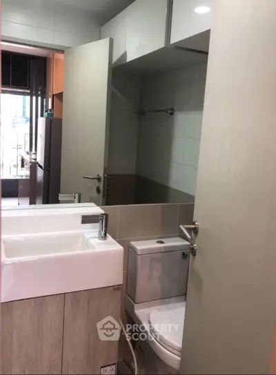 Modern compact bathroom with sleek fixtures and ample storage in urban apartment.