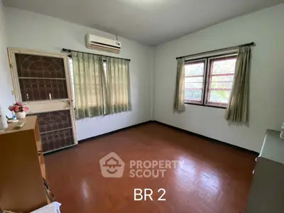Spacious bedroom with large windows, natural light, and air conditioning unit, ideal for comfortable living and personalization.