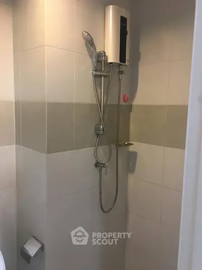 Compact bathroom with modern shower and water heater in tiled enclosure.