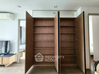 Spacious modern living room with built-in wooden storage cabinets and sleek design.