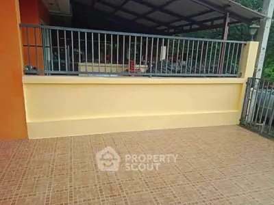 Spacious tiled patio with railing and covered area, perfect for outdoor relaxation and gatherings.