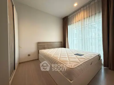 Spacious bedroom with large window and modern decor in a stylish apartment.