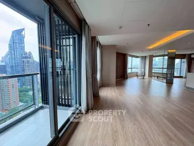 Spacious modern apartment with city view and large balcony in high-rise building.