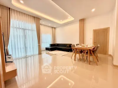 Spacious modern living room with elegant dining area and large windows.