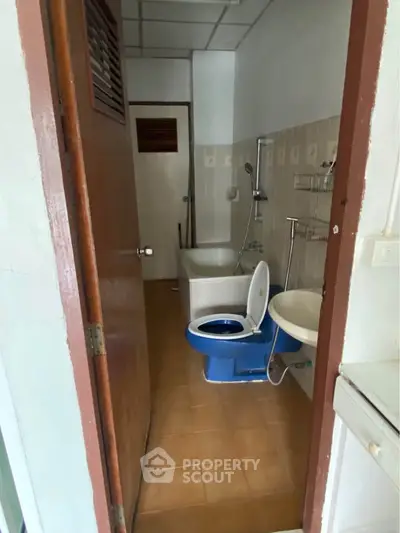 Cozy bathroom with bathtub and blue toilet in a compact layout