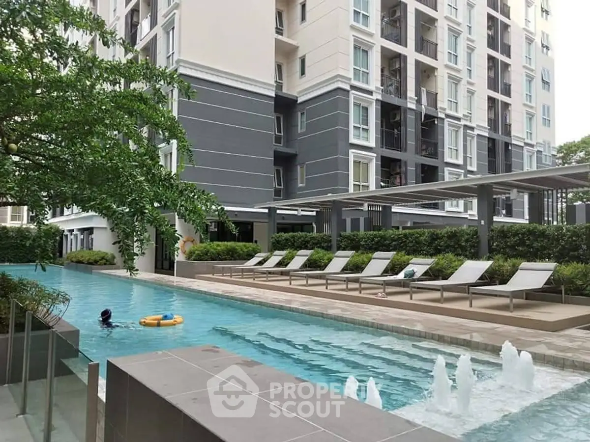 Luxurious condominium with modern pool and sun loungers, perfect for relaxation and leisure.
