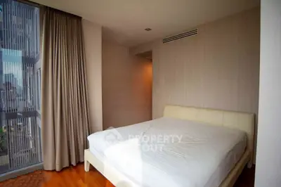 Spacious bedroom with large window offering city views and natural light.