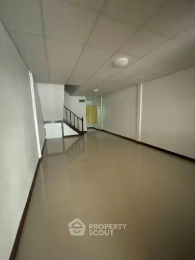 Spacious hallway with polished floors and staircase in modern building