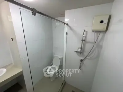 Modern bathroom with glass shower enclosure and white tiles