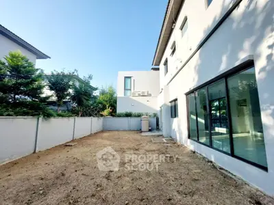 Spacious backyard of modern home with large windows and minimalistic design