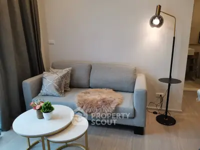 Stylish living room with modern sofa, chic lamp, and elegant coffee tables in a cozy apartment.