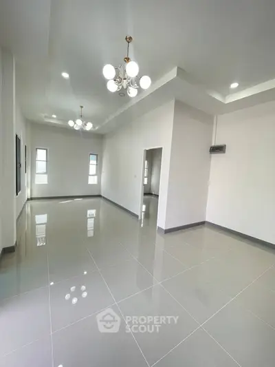 Spacious modern living room with elegant lighting and glossy tiled flooring.