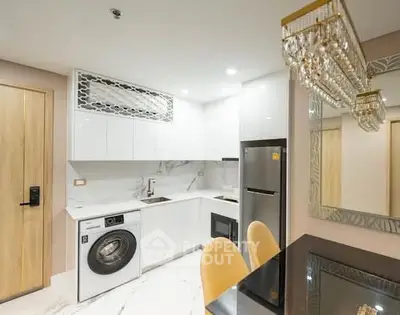 Modern kitchen with sleek appliances and elegant dining area in a stylish apartment.