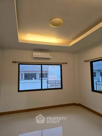 Bright room with large windows and air conditioning, ideal for comfortable living.