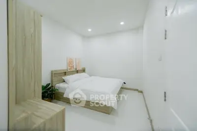 Modern minimalist bedroom with wooden furniture and white decor