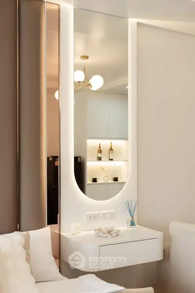 Modern interior with elegant mirror and cozy seating area, featuring stylish lighting and decor.