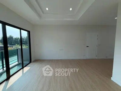 Spacious modern living room with large windows and balcony access