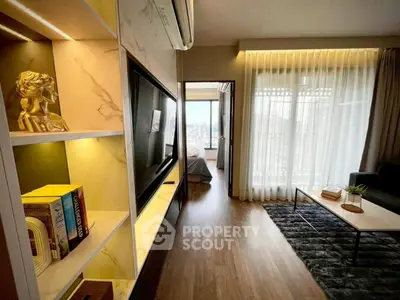 Modern living room with stylish decor and a view into a cozy bedroom, featuring elegant shelving and natural light.