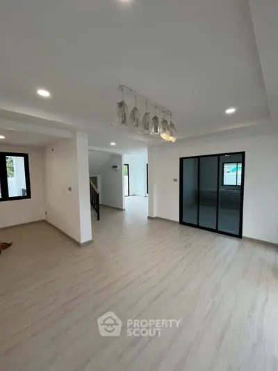 Spacious modern living room with elegant lighting and large windows in a contemporary home.