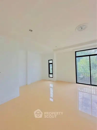Spacious empty room with large windows and garden view, perfect for customization.