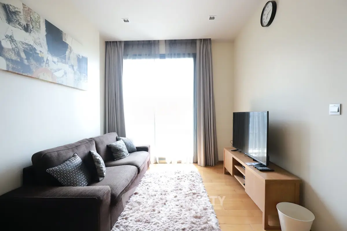 Cozy living room with modern decor, plush sofa, and large TV, perfect for relaxation and entertainment.