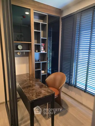Modern study room with sleek desk and stylish chair, featuring floor-to-ceiling windows with blinds.